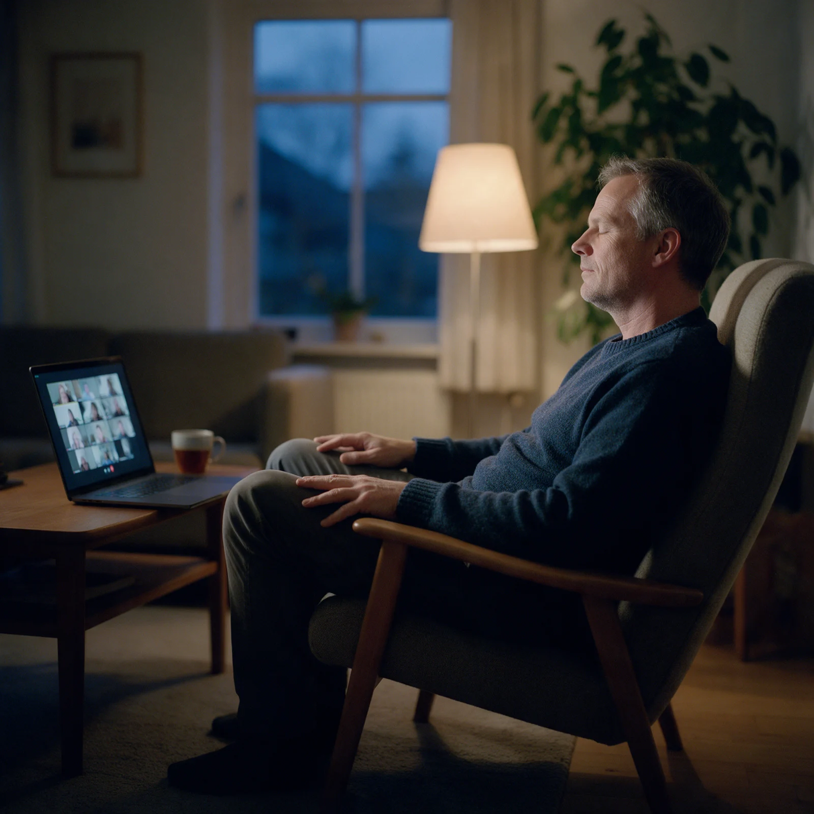 Man zit 's avonds met gesloten ogen ontspannen in een leunstoel, met de laptop op de salontafel voor de gezamenlijke Zoom-sessie van de schoningsavond van Leven op gevoel