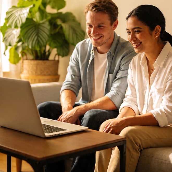 Stel kijkt samen naar laptop thuis tijdens een schoningsavond op afstand van Leven op gevoel