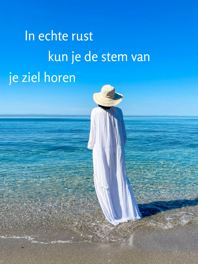 een serene foto van iemand aan zee, in wit gekleed, kijkend naar het water. met de tekst: In echte rust kun je de stem van je ziel horen